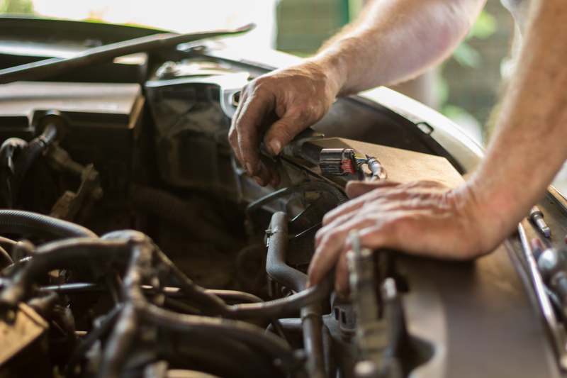 Auto mechanic working under the hood of an old car engine. mechanic working under the hood of a car engine in Fordham and Cambridgeshire